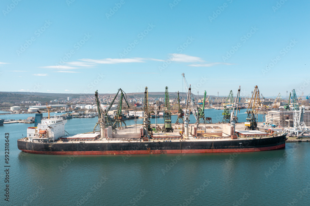 Black Sea Grain Initiative 2023 grain Deal. Port cranes loading of grain on a bulk carrier at sunny day. Panoramic shot made by drone
