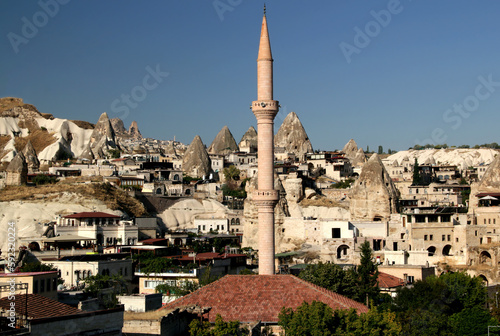 Panoramic view of the town of Goreme (Cappadocia, Turkey) with stone cave houses and the minaret of the mosque in the center of the photo in the foreground