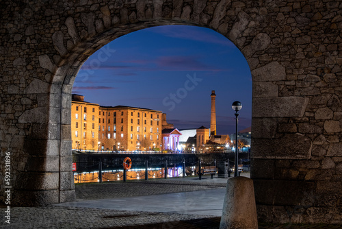 The Albert Dock and Pumphouse viewed through a remnant of the original dock wall at night, Liverpool Waterfront, Liverpool, Merseyside photo