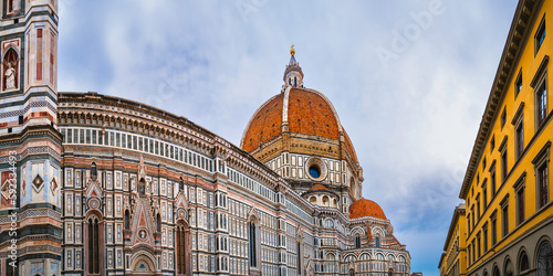 Duomo di Firenze, Cathedral of Santa Maria del Fiore with red-tiled dome and colored marble facade, and elegant Giotto tower in Florence, the capital of Tuscany region, Italy photo