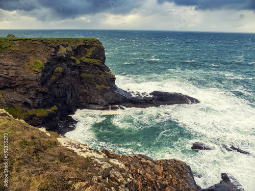 Rough stone coastline, Cliffs of Kilkee county Clare, Ireland. Wild Irish nature landscape. Popular travel area with stunning nature scenery. Dramatic sky and powerful ocean waves.