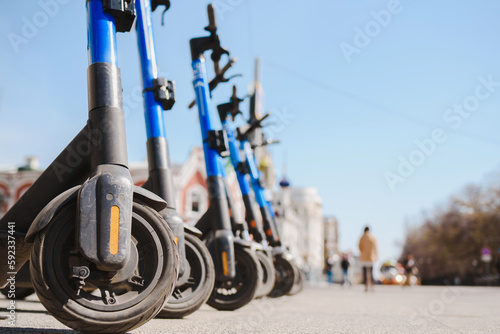 Electric scooters are parked in the city center. Modern public mobile transport