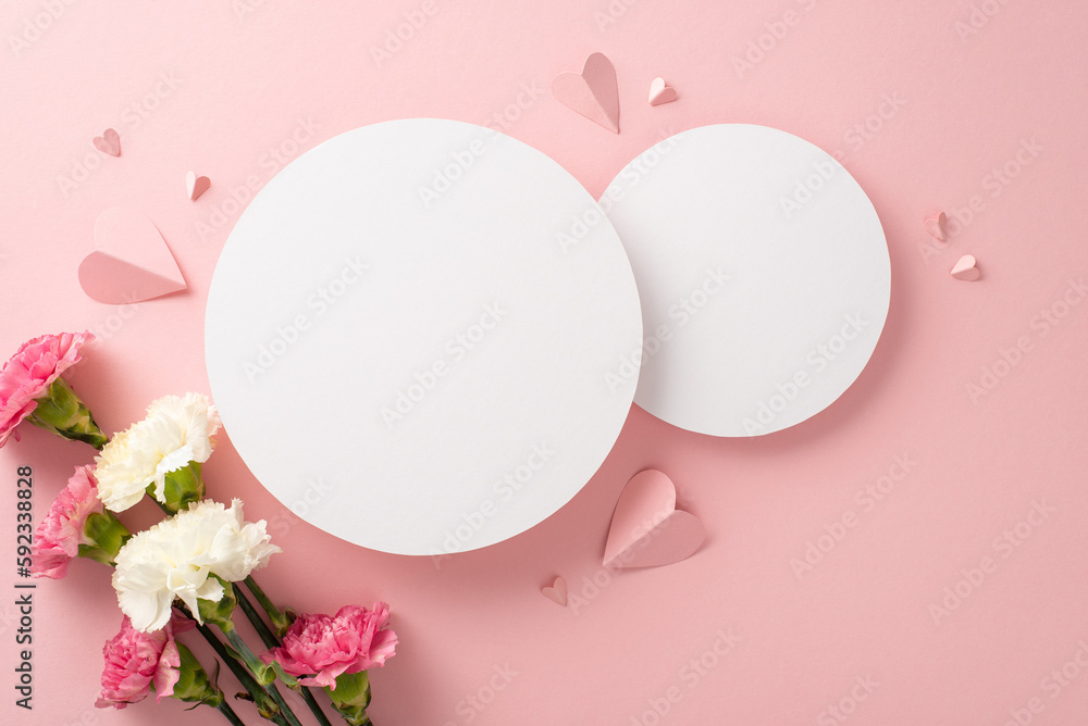 Top view of sweet carnation flowers, and heart-shaped papers on a pastel pink background, with two empty circles for text