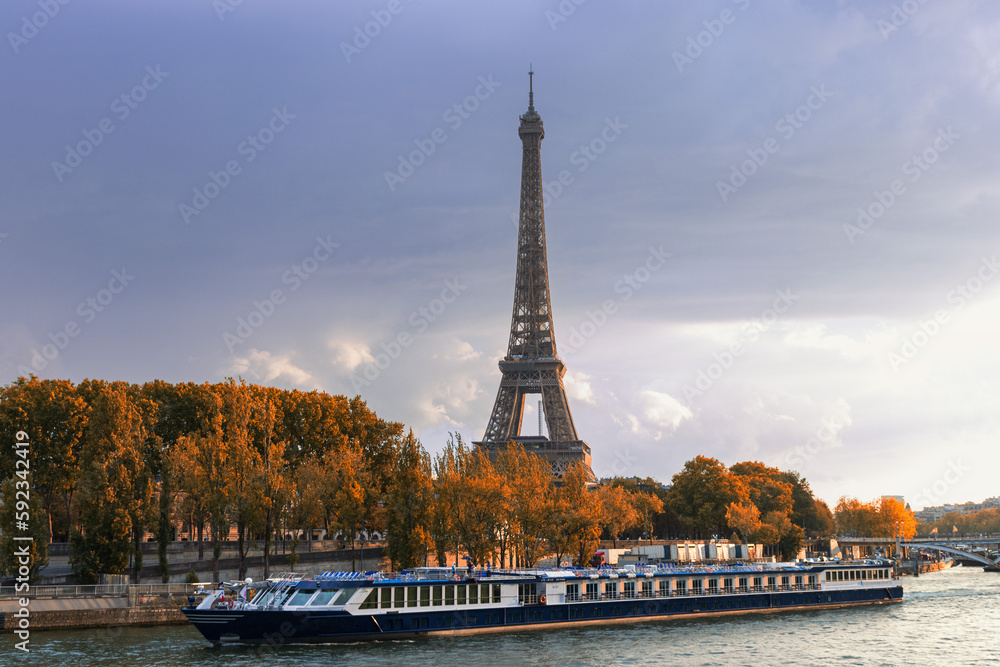 Boat sailing on the Seine in front of the Eiffel Tower on an autumn day