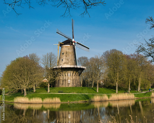 Eine holländische Windmühle auf einer Insel bei blauem Himmel und Sonnenschein im Frühling