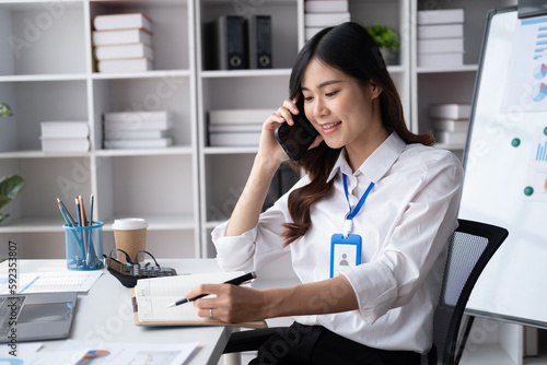 Professional business woman having a phone call with her coworker about the current project.