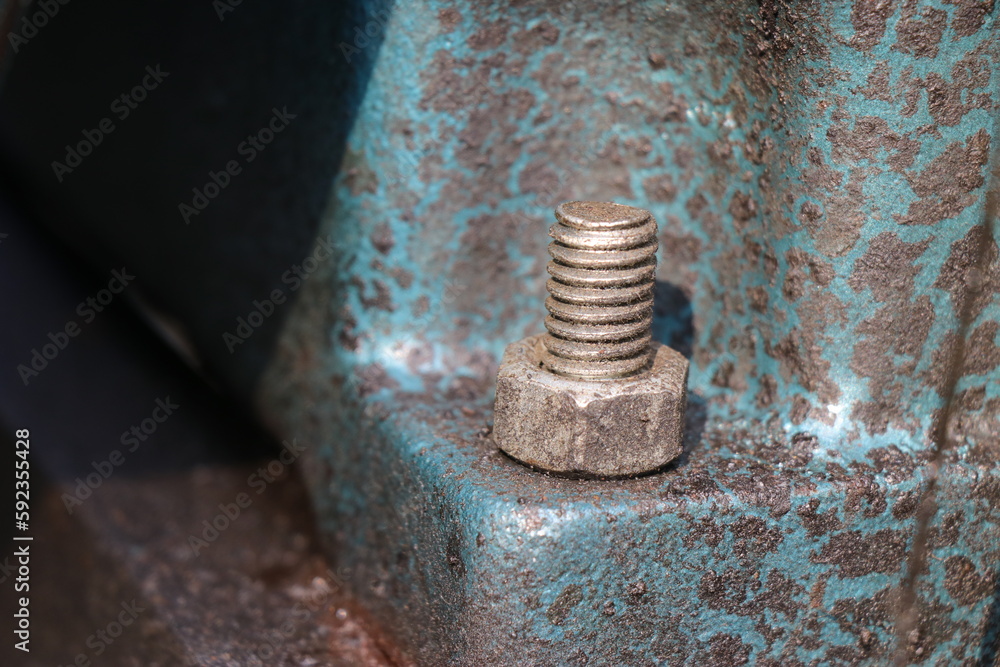Mild steel nut and bolt are fitted on a cast iron engine block base. Fastener with a view of threads Mild steel nut and bolt are fitted on a cast iron engine block base. Fastener with a view of threads