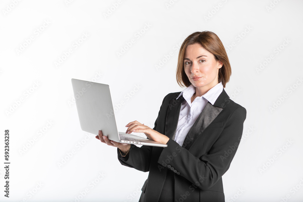 Young attractive and smiling business woman in black suit holding laptop isolated on white. Copy space and place for text concept Young attractive and smiling business woman in black suit holding laptop isolated on white. Copy space and place for text concept