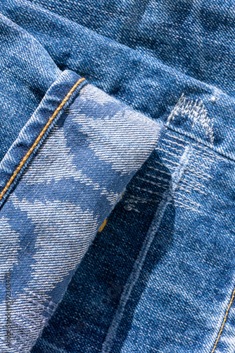 Blue jeans with patterns on the cuffs and decorative seams close up