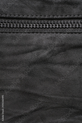 Crumpled black suede textured vertical background with black metal zip