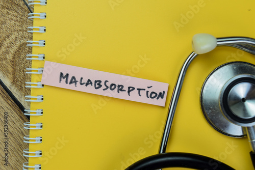 Concept of Malabsorption write on sticky notes with stethoscope isolated on Wooden Table. photo