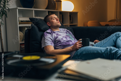 An attractive man enjoys to relaxing with good music in the evening