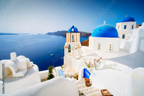 traditional greek village Oia of Santorini, with blue domes against sea and caldera with sunshine, Greece