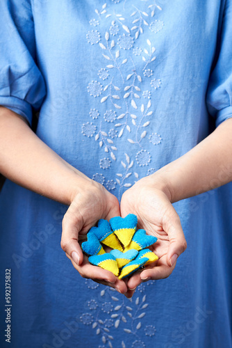 Wallpaper Mural Many heart shape pin badge made of blue and yellow stuffed felt in in women's hands. Topical issues of war. Freedom fighters. Support of nations, unity Torontodigital.ca