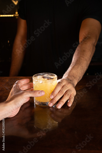 entregando bebida para o cliente no bar - serving a drink in the bar