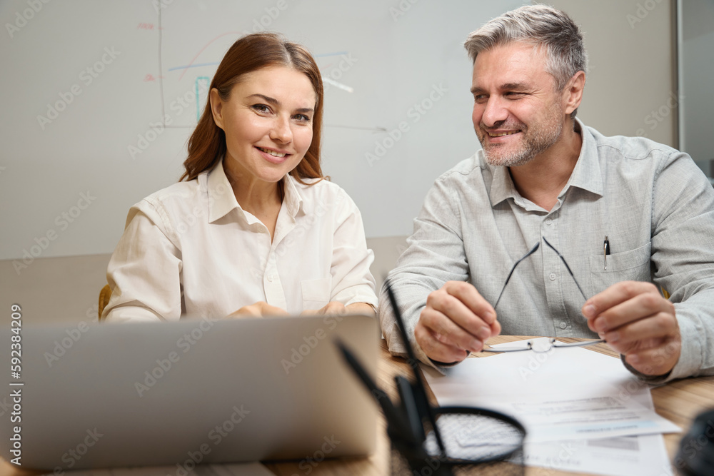 Obraz premium Smiling lady talking with male in the office
