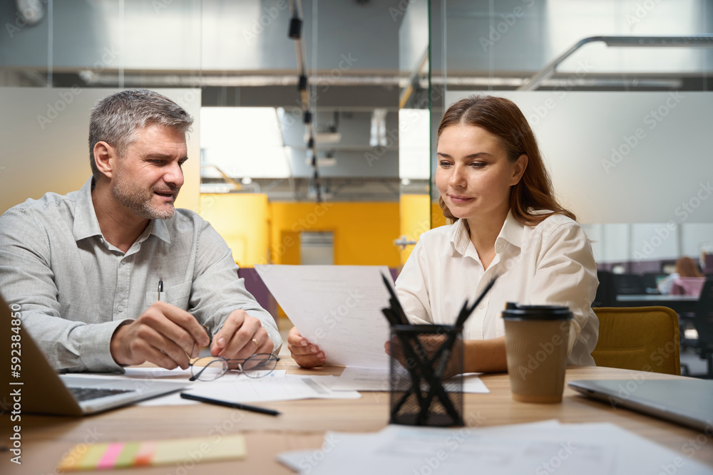 Obraz premium Man and woman discussing contract in the office