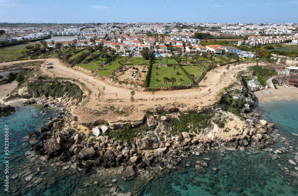 Drone aerial of holiday village with luxury houses at an idyllic rocky coast. Summer vacations at the sea. Protaras Cyprus