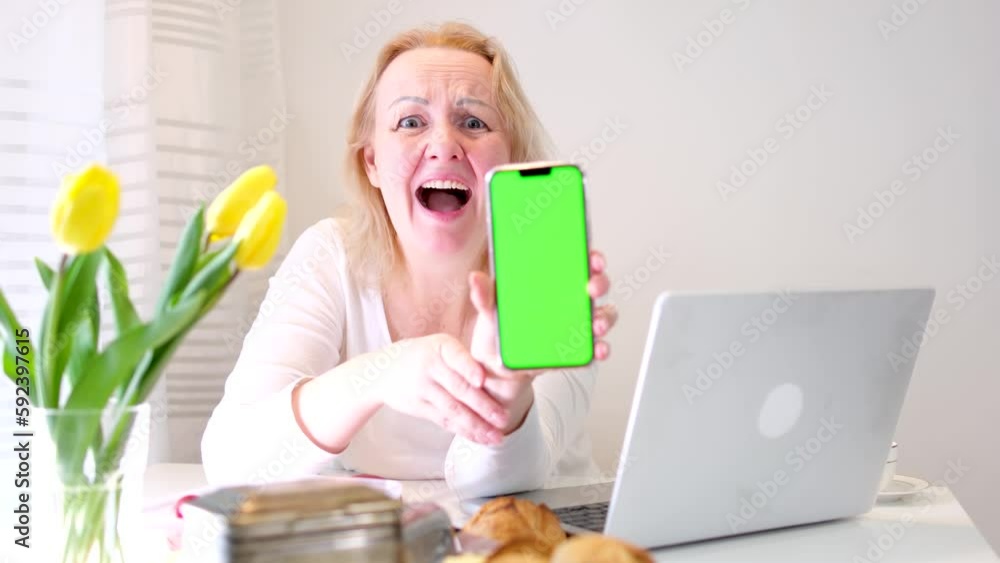 woman seems to be typing message or opening some site then turns screen green instead of for ad thumbs up smiles laughs points her finger at place for text and advertising near laptop in white woman seems to be typing message or opening some site then turns screen green instead of for ad thumbs up smiles laughs points her finger at place for text and advertising near laptop in white