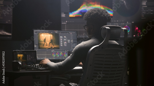 Φωτογραφία African American film editor does color grading on computer in modern studio