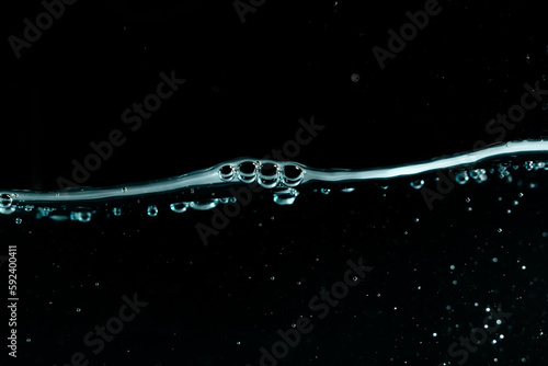 Water surface with bubbles on black background.
