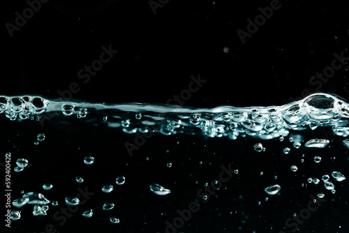 Water surface with bubbles on black background. 