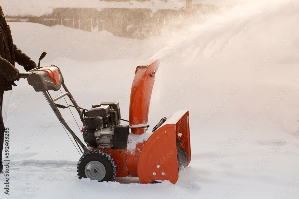 Fototapeta premium A portable snow blower powered by gasoline. Snow removal in winter.