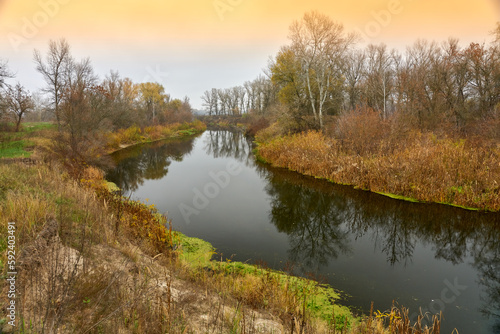 Fototapeta Naklejka Na Ścianę i Meble -  Winding river with reeds and trees along the banks.