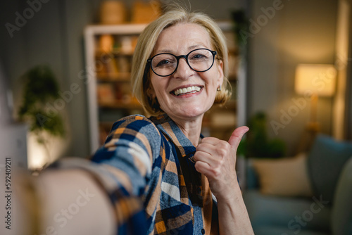 Fotografiet Portrait of one mature blonde caucasian woman with eyeglasses at home