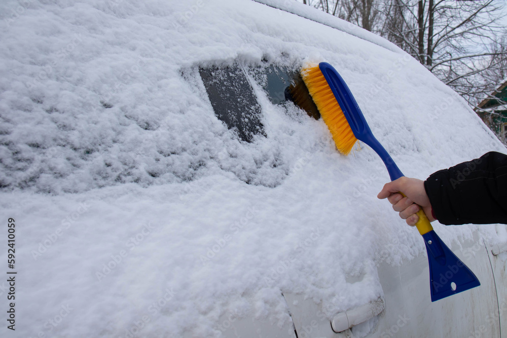 Cleaning the car from snow. The scraper clears the car of snow. Cleaning the car from snow. The scraper clears the car of snow.