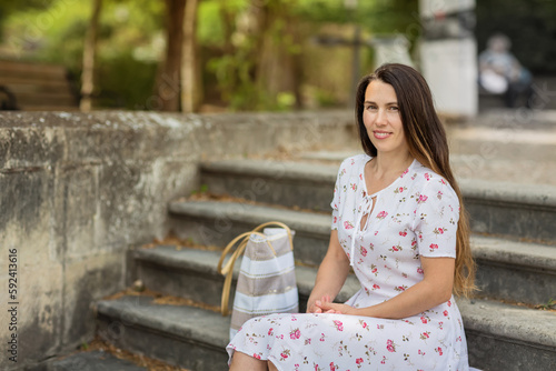 Pretty woman sitting and posing on ancient stone stairs