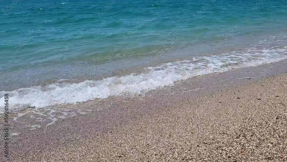 Turquoise waves breaking on the beach on a clear sunny summer day Turquoise waves breaking on the beach on a clear sunny summer day