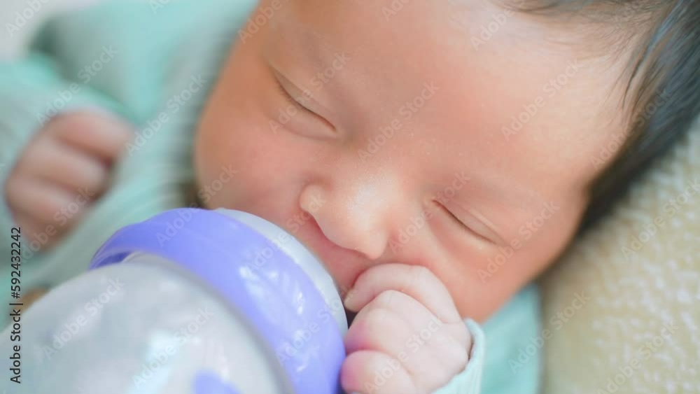 Loving mother feeding her little girl child with breast milk baby
