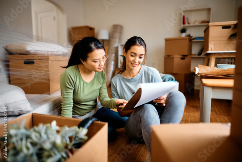 Konstfotografi Young women going through housing plans after moving into their new home