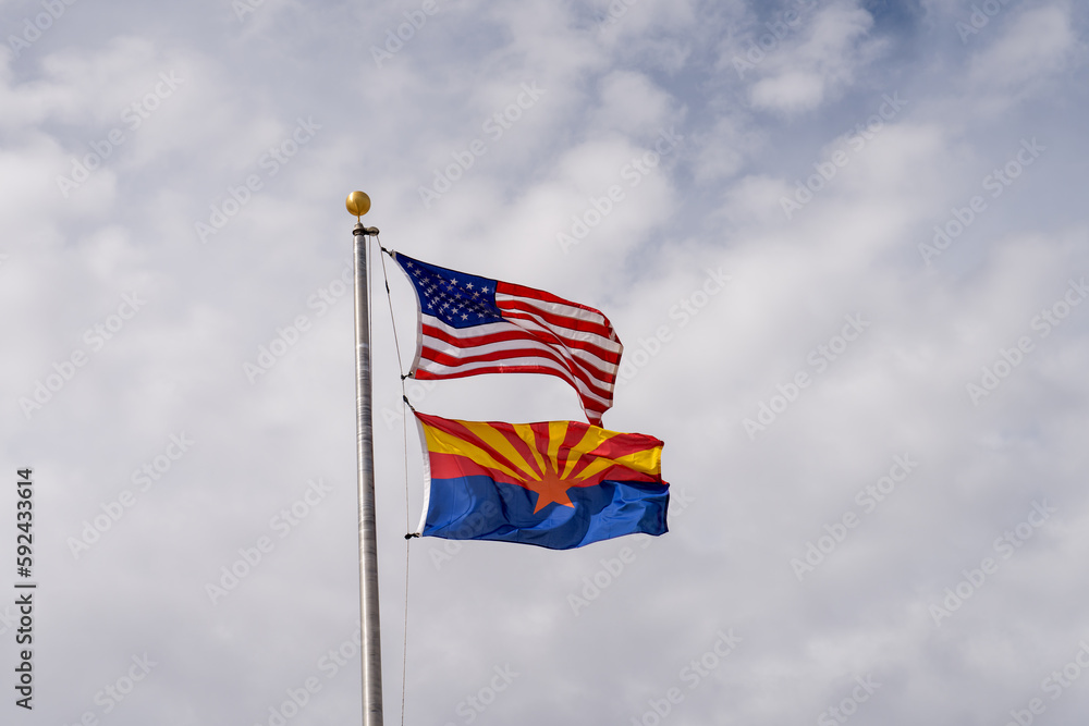 United States and Arizona flags flying on a pole together United States and Arizona flags flying on a pole together