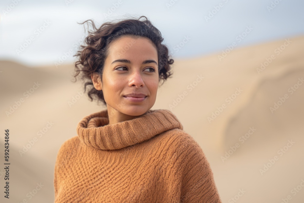 Beautiful young woman with curly hair and brown sweater in the desert