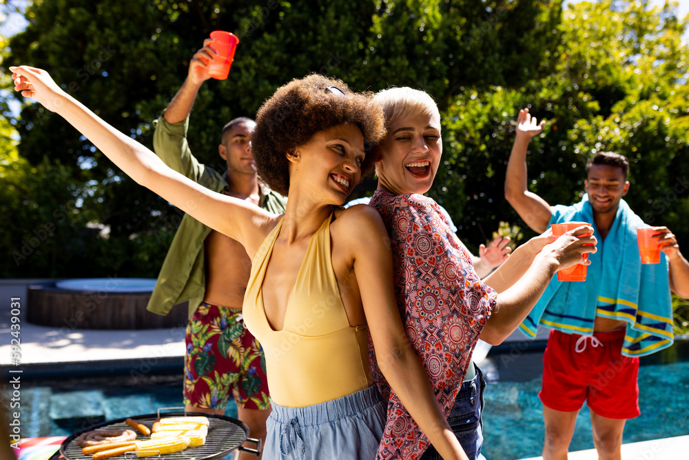 Happy diverse group of friends having pool party, barbecuing and ...