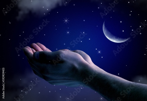 Pray hands open to the blue night sky