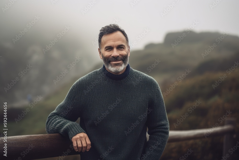 Portrait of a smiling mature man standing outdoors on a foggy day