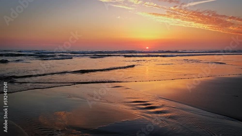 Atlantic ocean sunset with surging waves at Fonte da Telha beach, Costa da Caparica, Portugal photo