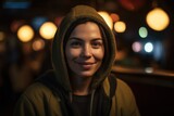 Portrait of a smiling young woman wearing hoodie in a restaurant