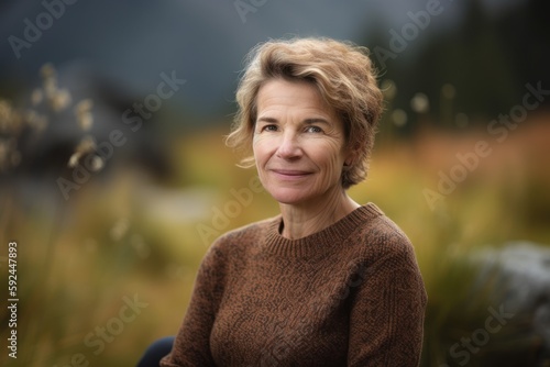 Portrait Of Mature Woman Relaxing In Autumnal Landscape