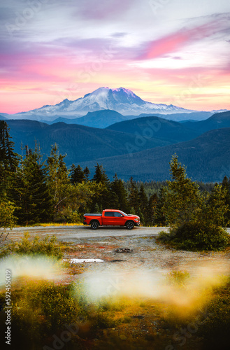A pickup truck in front of volcanic mountain. Mount Rainier in the background in Washington State. A perfect spot for camping off the grid. © Victoria Nefedova