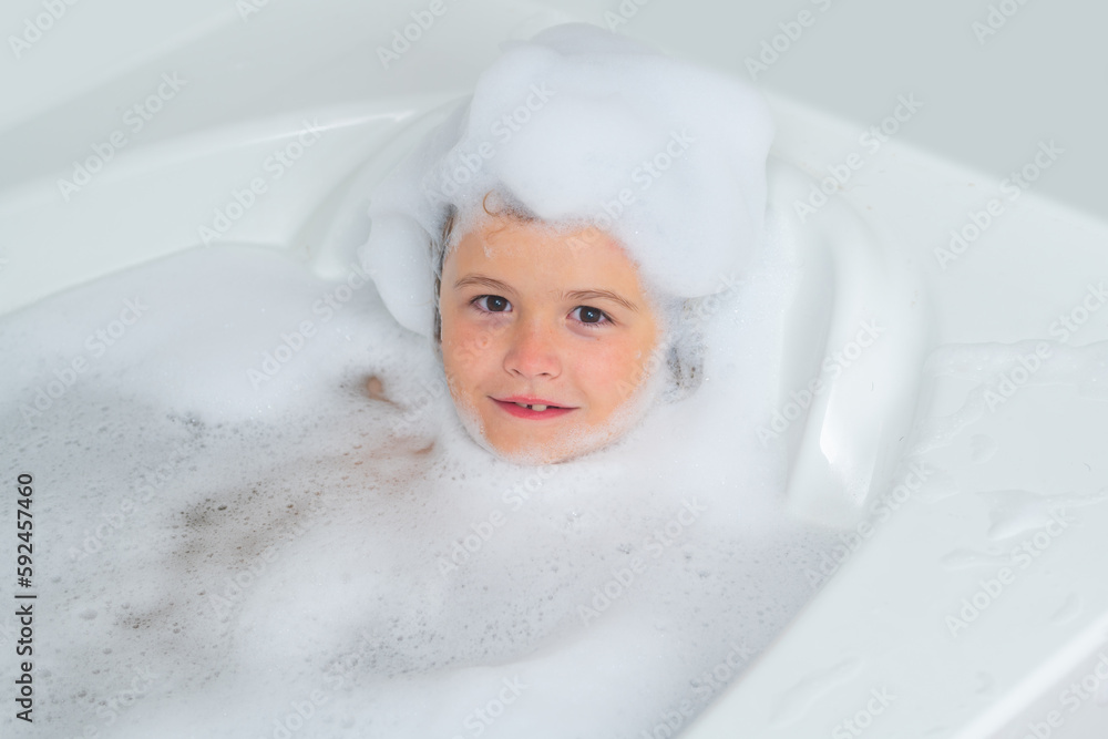 Foam on kids head. Soap on child head. Kid having fun in the bath with