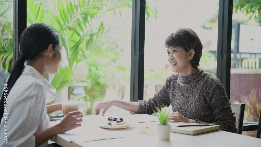 Business concept of 4k Resolution. Asian business people having a meeting in a coffee shop. Service of cafe staff. Business concept of 4k Resolution. Asian business people having a meeting in a coffee shop. Service of cafe staff.