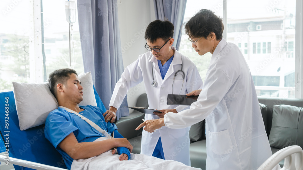 Fototapeta premium The medical team visits the car accident patients who are lying on the nursing bed and arm cast with wrapping nurse bandages splint to the arm.