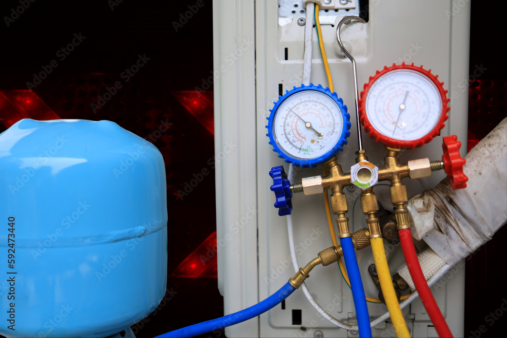 The refrigerant tank and manifold gauge are being used to fill the air