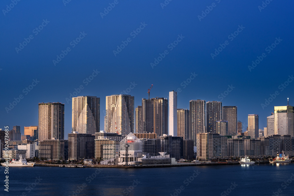 Obraz premium 夕暮れ時の東京湾レインボーブリッジから見る晴海ふ頭とタワマン群