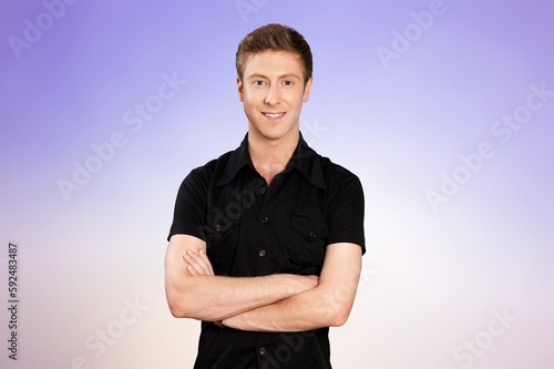 Happy young man standing with crossed arms