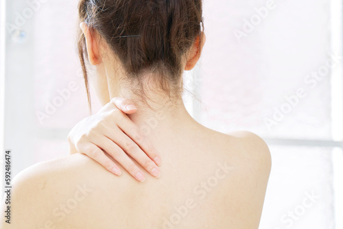 背中・肩のスキンケアをする若い女性